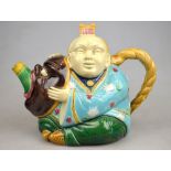 A Victorian Minton majolica teapot in the form of a Chinaman astride a mythical beast, impressed