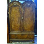 A Queen Anne style double dome top feather banded walnut cupboard, the interior with hanging space