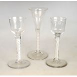 Three 18th century cordial glasses - two with ogee bowls, one of which is engraved with a flower and
