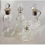 A glass 'glug-glug' decanter with silver collar, to/w three other decanters, also with silver