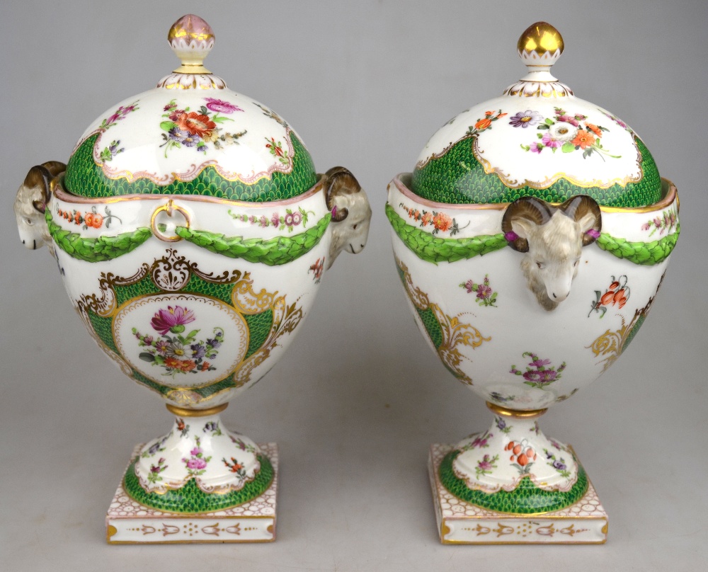 A pair of Dresden ovoid vases and covers raised on a circular pedestal on a square base, having