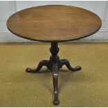 A George III fruitwood tripod table, having a circular tilt top over a pad foot base, 70 cm high x