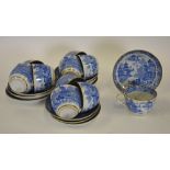 An early 19th century blue and white willow pattern tea service bordered with gilt and comprising