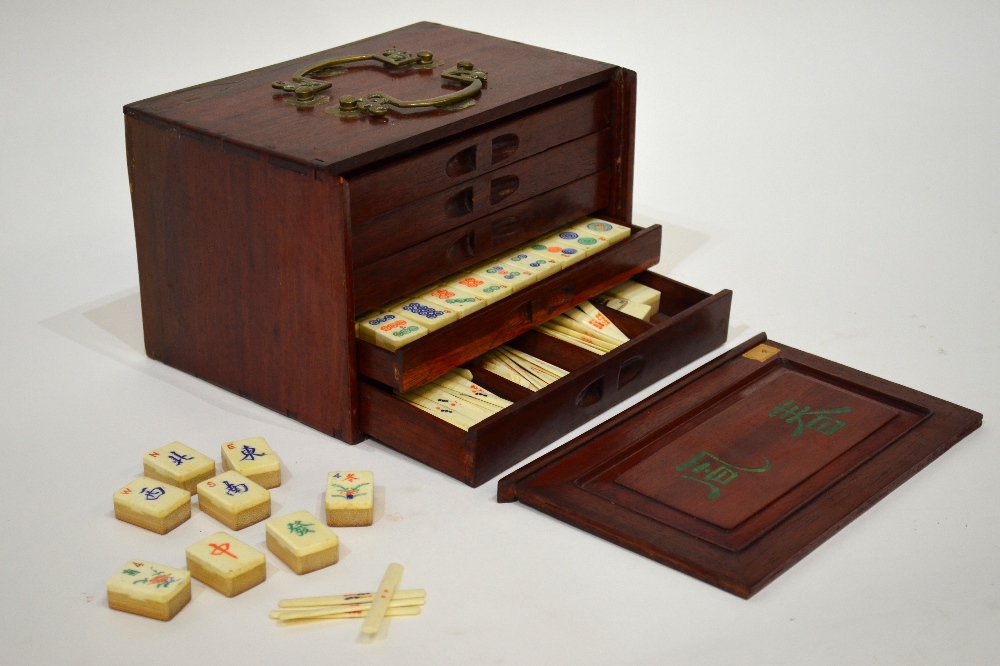 A Chinese Mah Jong set, the hardwood box sliding open to reveal five drawers containing bamboo and