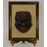 A Japanese hardwood carved mask of a gri