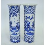 A pair of Chinese blue and white cylindrical vases with flared rims decorated with panels of figures