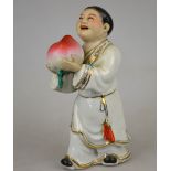 A Chinese porcelain famille rose figure of a man holding a giant peach, 20th century, 22 cm h.