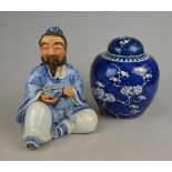 A Chinese porcelain figure of a seated man holding a bowl, 16.5 cm h. to/w a blue and white jar