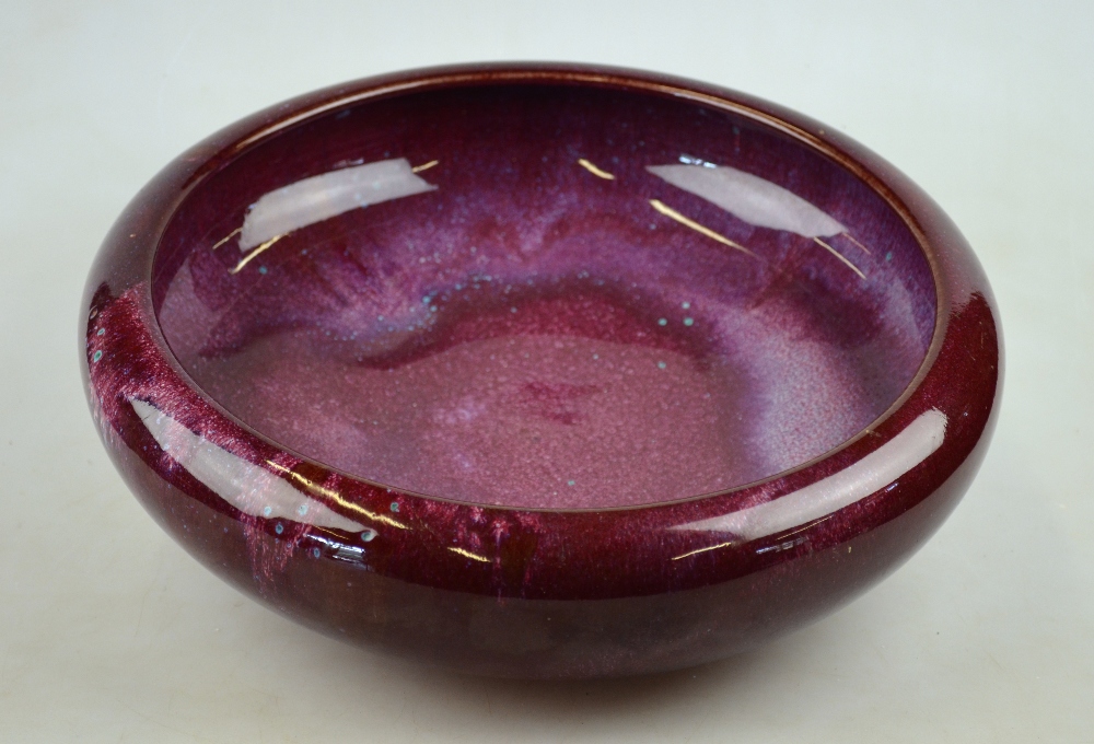 A 19th century Chinese sang de boeuf-glazed bowl with rolled rim, on shallow foot, 30 cm diam