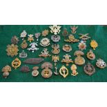 A quantity of military cap badges includ