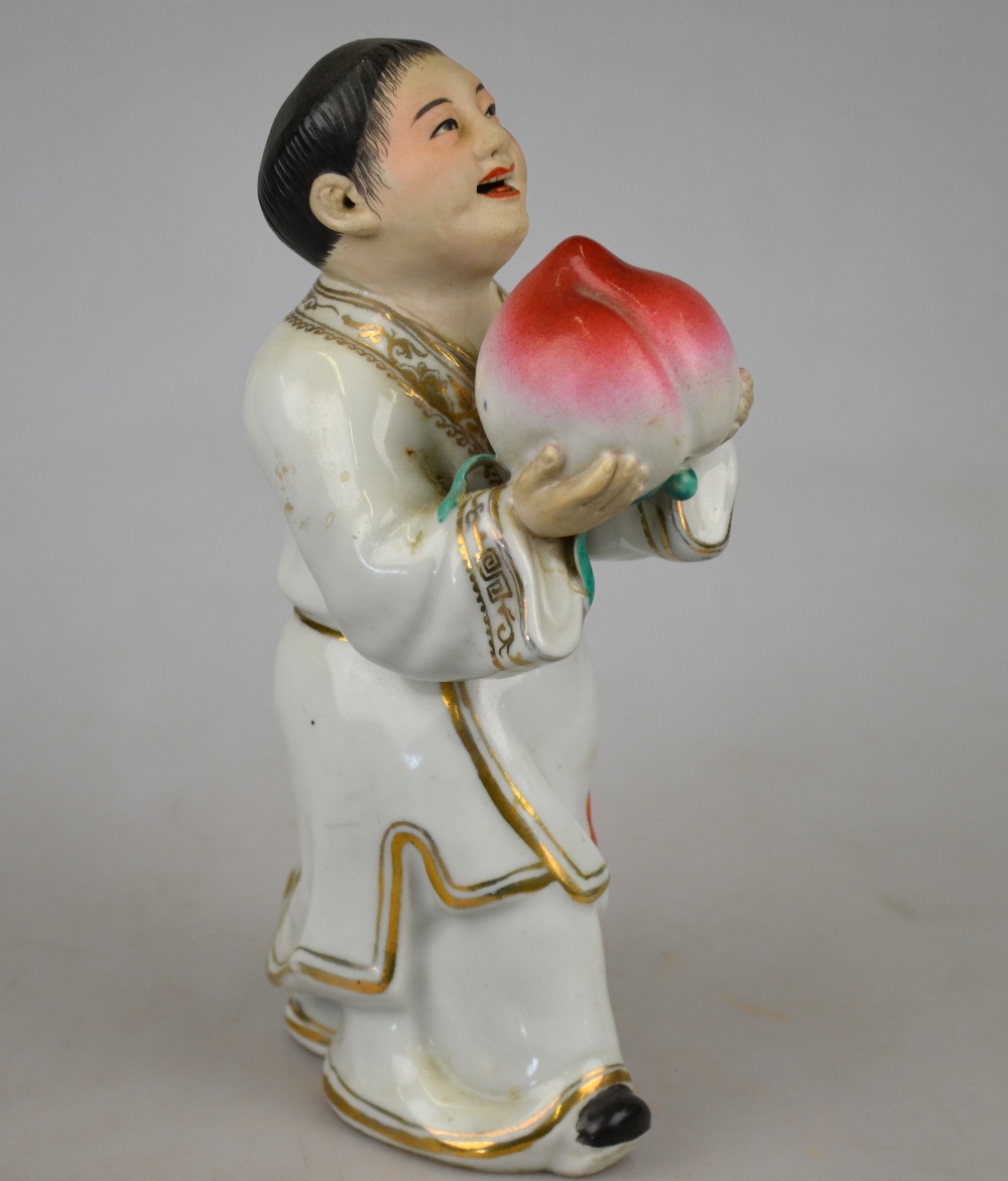 A Chinese porcelain famille rose figure of a man holding a giant peach, 20th century, 22 cm h. - Image 2 of 4