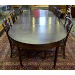 A 19th century mahogany extending dining table comprising a pair of demi-lune drop leaf tables and