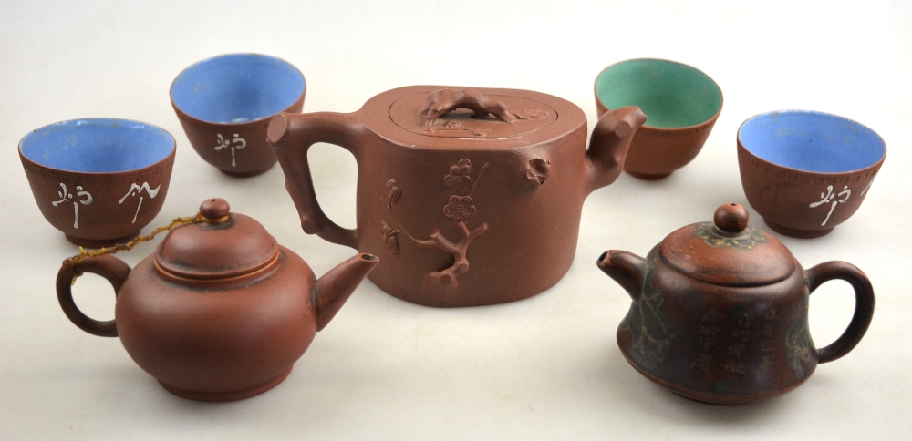 Three Yixing teapots, one incised with calligraphy to/w four tea bowls with glazed interiors (7)