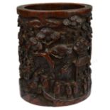 A Chinese bamboo brush pot carved with numerous figures on a mountainous path with buildings and