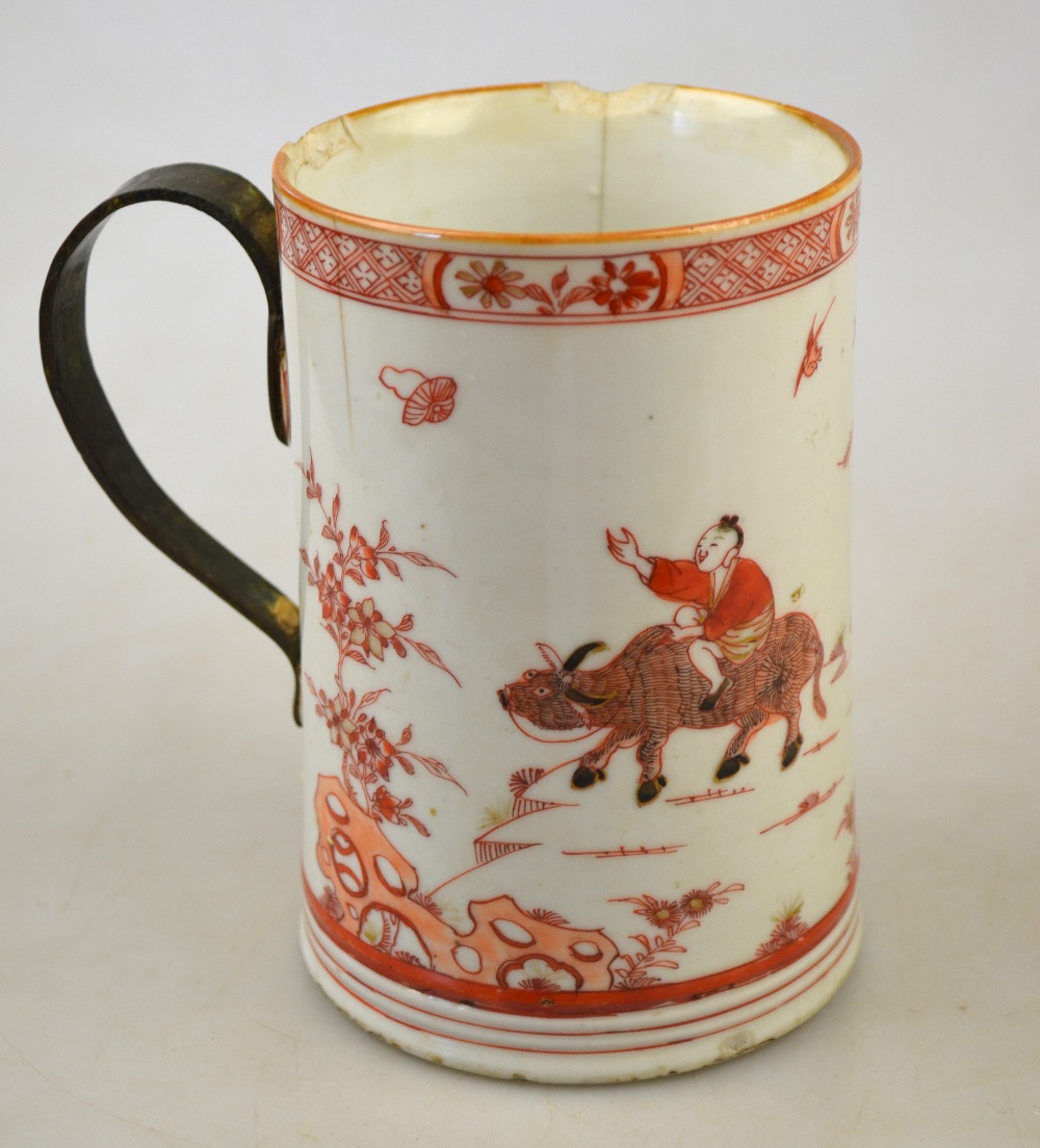 A Chinese Imari tankard decorated with a boy and water buffalo in a rocky landscape with pine