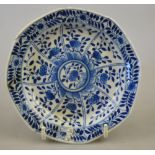 A Chinese blue and white moulded saucer decorated with panels of foliage, Kangxi four character mark