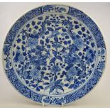 A Chinese blue and white charger, 19th century, decorated with dragons amidst flowers and foliage,
