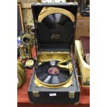 A Jedson De Luxe picnic gramophone with gilt metal interior and three 78 records