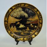 A Chinese black lacquer circular tray decorated in gilt with figures swimming amongst lotus in a