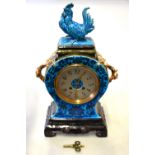 A 19th century French blue-glazed majolica-cased mantle clock surmounted by a cockerel and with