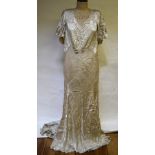 A 1930's cream silk satin court dress with floral roundels highlighted in gold thread, bias cut with