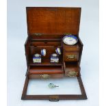 A Victorian oak stationery case with hinged top and glazed fall front, fitted with rack, drawer,