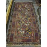 An antique Belouch long rug, the multi-coloured geometric design on red/brown ground, 2.34 x 1.10