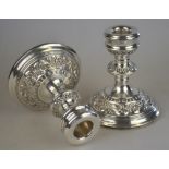 A pair of loaded silver short candlesticks with foliate embossed and chased decoration, W. I.