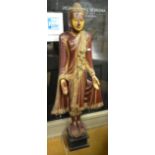 A Burmese standing Buddha, c. 1900, lacquered and gilded and having glass inset flower heads, 153 cm