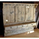 A 19th century pine panelled hanging rack with three small drawers,