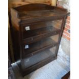 A 'Lebus' glazed oak three section bookcases beneath a 3/4 galleried top and raised on a shaped