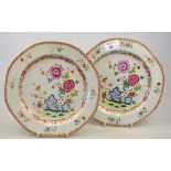 A pair of Chinese famille rose porcelain plates decorated with flowers, foliage and rockwork, 18th