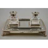 A George IV silver ink standish with double pen-trays and gadrooned rim, on cast leaf and claw feet,