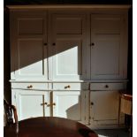 A large Victorian painted pine housekeepers cupboard, having a trio of twin panelled cupboards