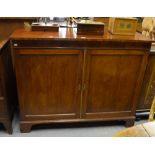 A Victorian mahogany side cabinet having a pair of fielded panel doors enclosing shelves,