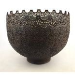 An antique Persian bowl cast overall with a foliate filigree pattern and having a crenulated