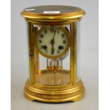 A French lacquered brass, four glass, 8-day mantel clock of oval form,