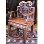 A Chinese hardwood throne chair, the back carved with a circular panel of figures beneath pine