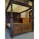 A substantial part 17th century oak full tester bed having a panelled back board and conforming