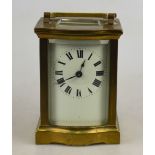 A brass carriage timepiece with bow front and enamel dial,
