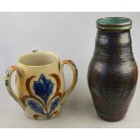 A 19th century Arts & Crafts stoneware loving cup decorated with incised blue and brown leaves on