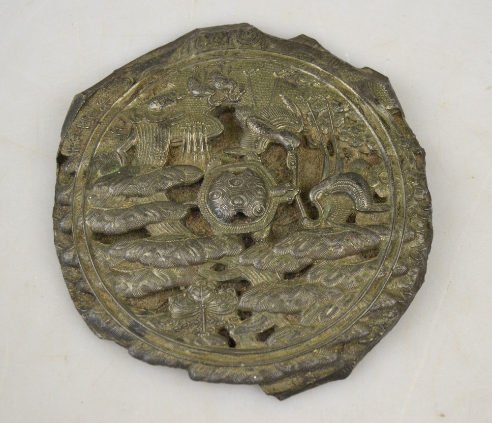 A Japanese white metal mirror cast with a central tortoise surrounded by storks and other long life