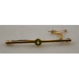 A yellow gold bar brooch set with peridot,