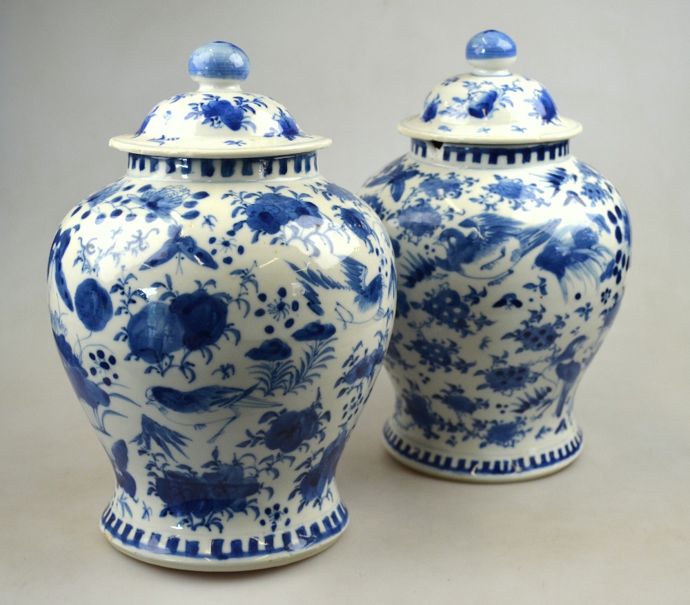 A matched pair of Chinese blue and white porcelain vases and covers each decorated with birds and