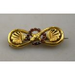 A Victorian coiled snake brooch with garnet set circle in centre,