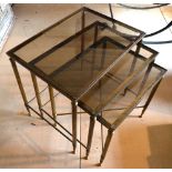 A graduated nest of three brass framed occasional tables, each having a glass insert top,