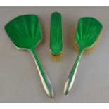 A silver and green basse-taille enamel three-piece brush set, Henry Clifford Davis, Birmingham