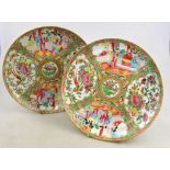 A pair of Chinese Canton famille rose plates decorated with alternating panels of figures on a