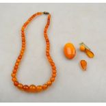 A single row of graduated amber beads to/w oval cabochon amber brooch and remains of one other