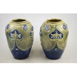 A pair of Royal Doulton stoneware ovoid vases decorated with stylised flowers on a mottled blue